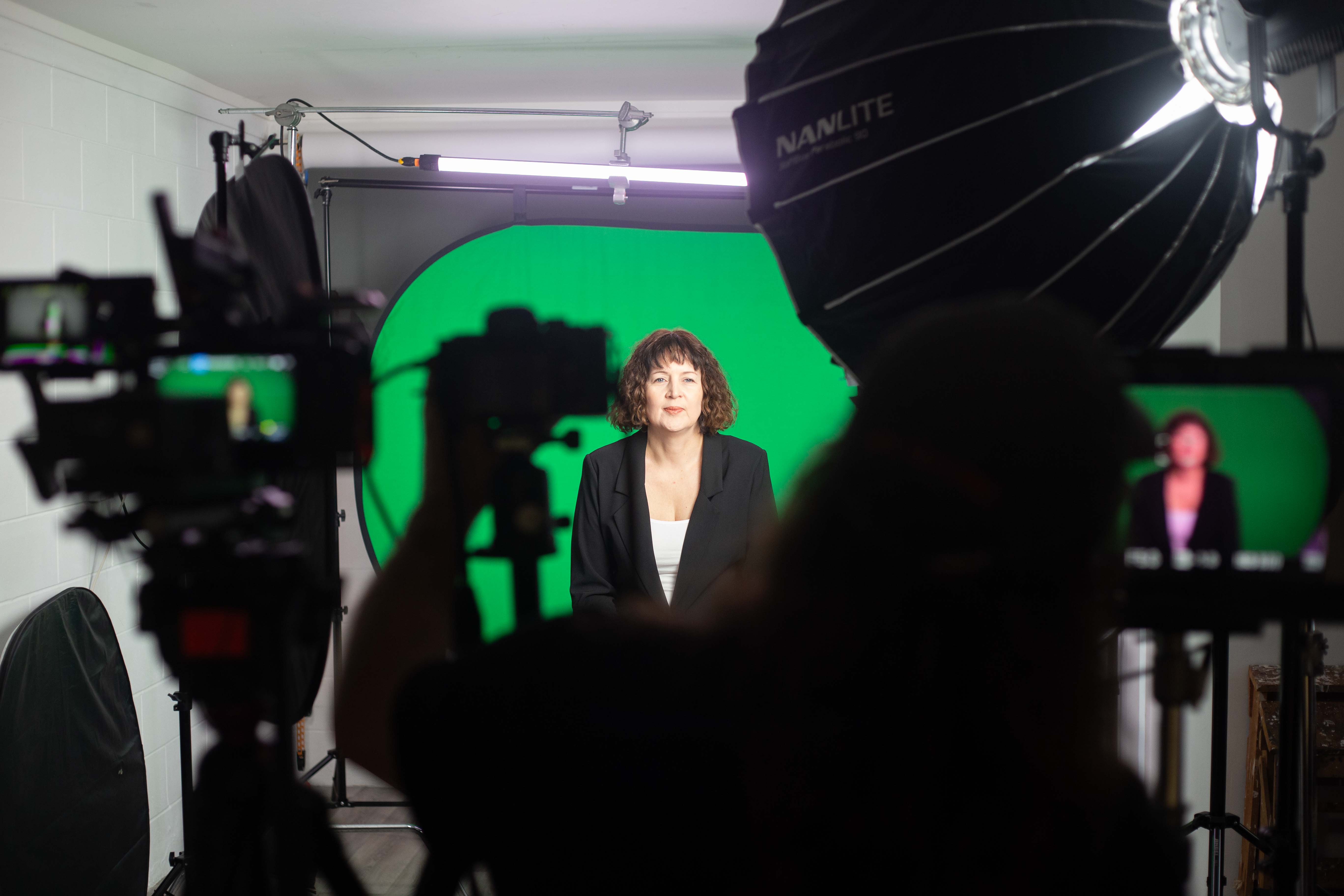 Client being filmed in a professional digital twin studio setup with green screen